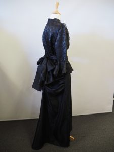 Black Victorian ladies costume, includes a high necked blouse and bustled skirt