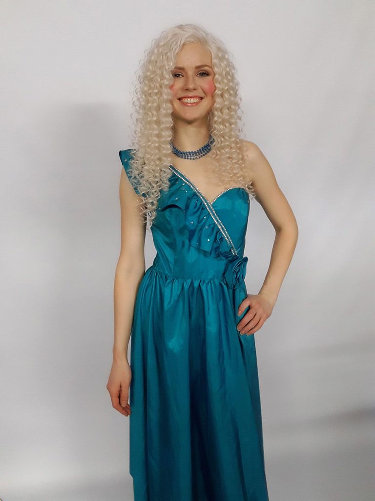 Model is wearing a aqua blue one shoulder 1980s dress