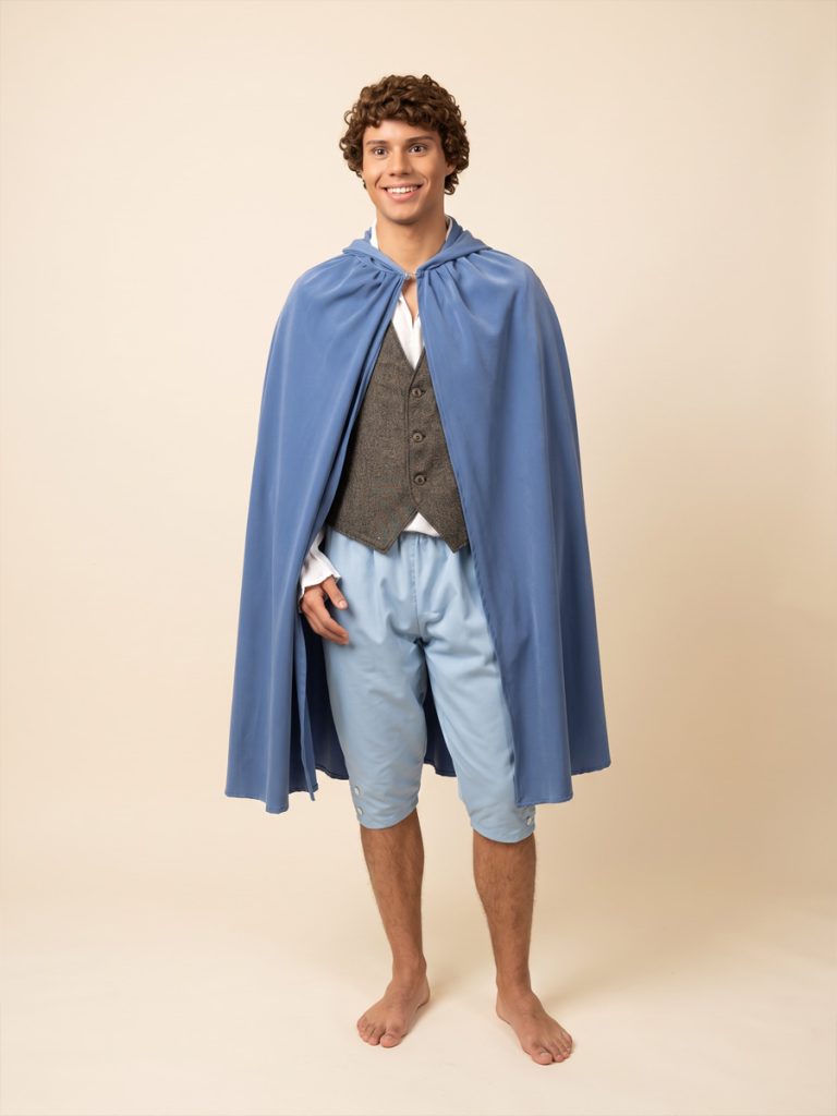 Image is a model wearing a Hobbit style costume including a blue cape, tweed waistcoat & blue crop pants